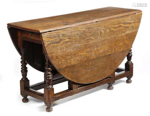 A Queen Anne oak gateleg table, the oval drop-leaf top on spiral twist, urn and block supports,