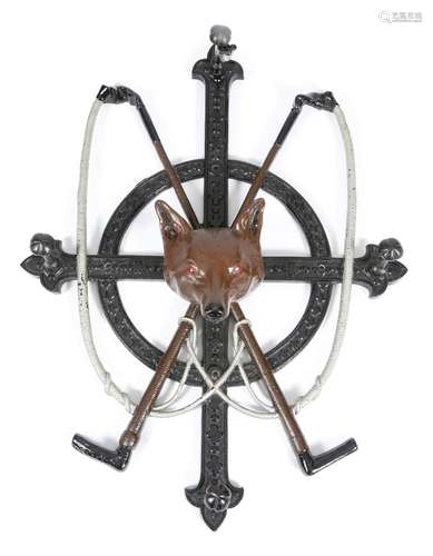 A Victorian painted cast iron wall hanging whip rack, formed with a pair of crossed whips, centred