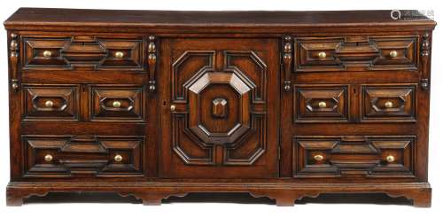 A late 17th century oak dresser, the boarded top above a geometric panelled cupboard door