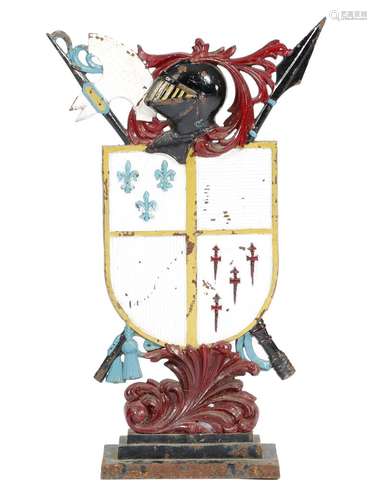 A late Victorian painted cast iron doorstop, in the form of a coat of arms, with a helm and leaf