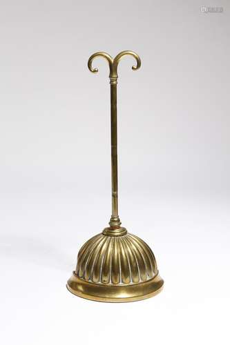 A Victorian brass doorstop, with a scroll handle and a lobed bell shaped weighted base, stamped with