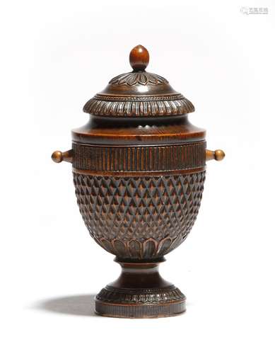 An early 19th century treen urn, the cover decorated with bands of leaves, above a pineapple type