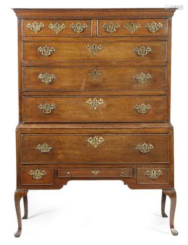 A mid-18th century oak chest on stand, the moulded cornice above two short and three long drawers,