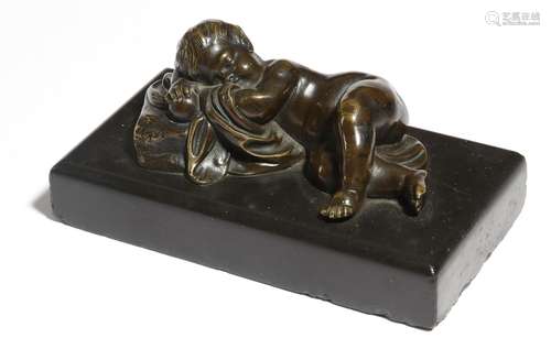 An early 19th century bronze and black marble paperweight, modelled with a sleeping cherub, 14cm