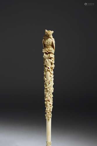 λ A Victorian ivory parasol handle, carved with an owl reading a book, perched on a branch with