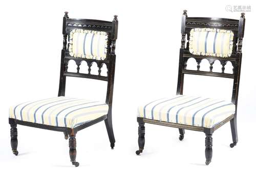 A pair of late Victorian Aesthetic Movement ebonised nursing chairs, one with parcel gilt