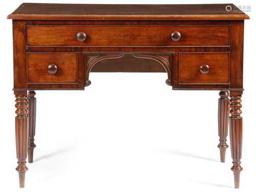 A William IV mahogany kneehole dressing table, fitted with three drawers, on turned and ribbed