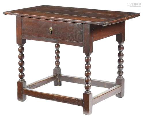 An early 18th century oak side table, the boarded top with cleated ends, above a frieze drawer, on