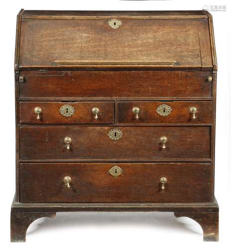 A George I oak bureau, the hinged fall with a rest, enclosing a stepped interior with drawers and