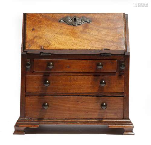 A 19th century mahogany miniature bureau in George III style, the hinged fall revealing pigeonholes,