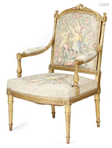 A French giltwood fauteuil in Louis XVI style, with a padded back, seat and armrests, covered with