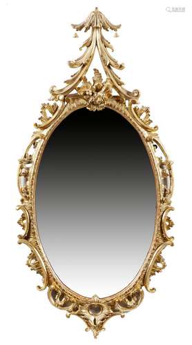 An early George III giltwood wall mirror, the later oval plate within a rocaille and 'C' scroll