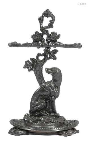 A Victorian cast iron stickstand, naturalistically modelled with a seated dog below a tree, with two