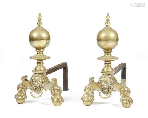 A pair of Dutch brass andirons, with turned ball finials, above lion's masks, on claw and ball feet,