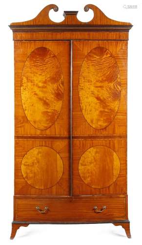 A late Victorian satinwood bowfront single wardrobe in Sheraton style, inlaid with stringing, the