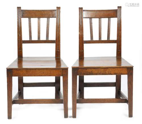 A pair of early 19th century country oak side chairs, each with a solid seat, on tapering front legs