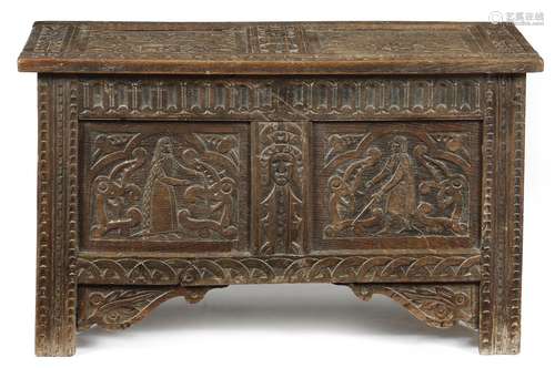 A carved oak marriage chest, the twin panelled lid decorated with coats of arms, with an eagle and