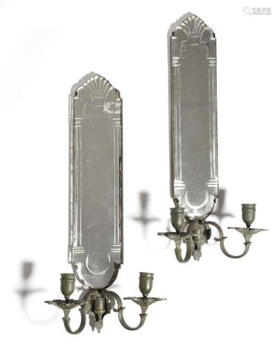 A pair of 18th century style wall sconces, each with a cut mirrored back, above a pair of bronze