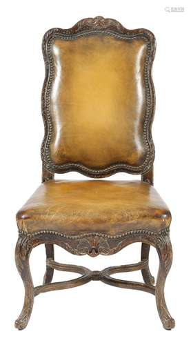 A French oak side chair in Louis XV style, with a padded back and seat covered in brown studded