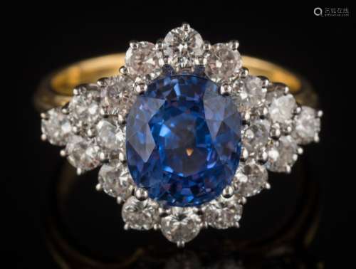 An 18ct gold, sapphire and diamond oval cluster ring: with central oval sapphire approximately 9.