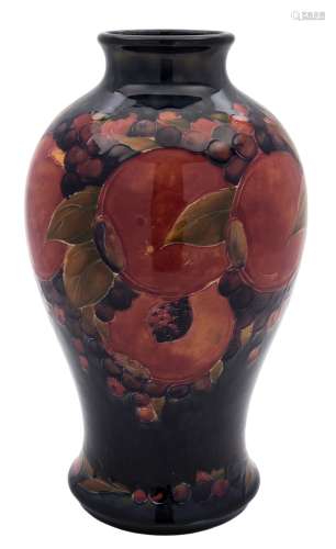 A Moorcroft pottery vase: of baluster form tube lined in the Pomegranate pattern in red, purple,