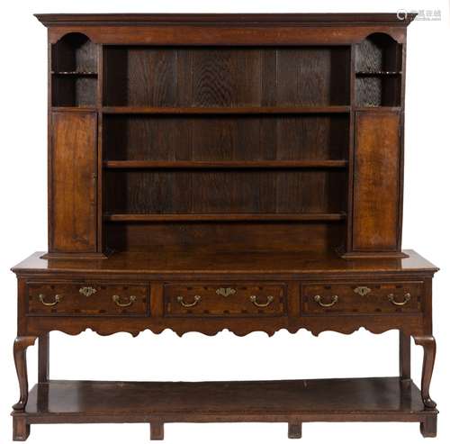 An 18th Century and later oak dresser: the later shelved superstructure with a moulded cornice and