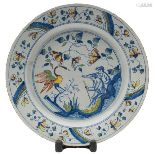 A Bristol polychrome delftware dish: painted with two men seated on rockwork pointing towards a