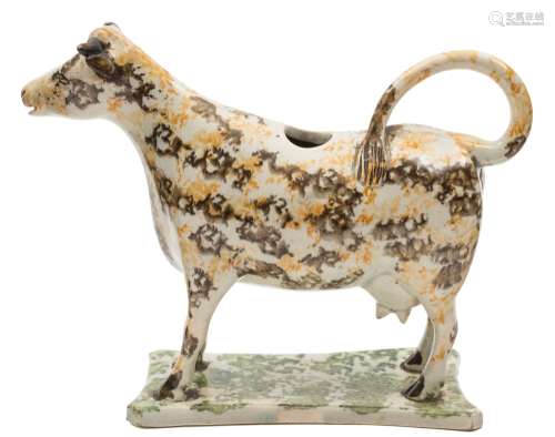 A Staffordshire creamware cow creamer: painted in marbled grey, ochre and green glazes,