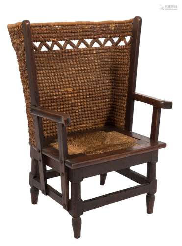 A child's Orkney Islands oak wing armchair:, with curved rope pattern back,