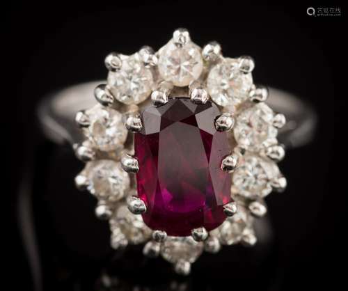 An 18ct white gold, ruby and diamond oval cluster ring: with central oval ruby approximately 9.