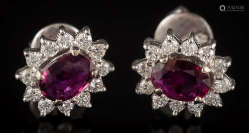 A pair of ruby and diamond oval cluster ear-studs: each with a central oval ruby 6.3mm long x 4.