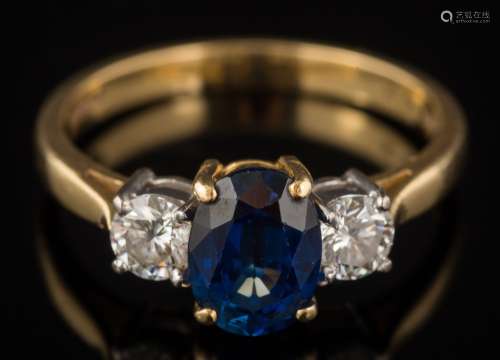 An 18ct gold, sapphire and diamond three-stone ring: with central oval sapphire approximately 7.