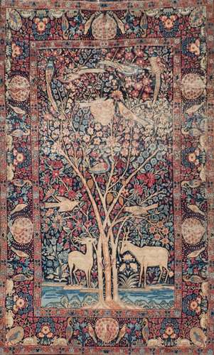 An Isfahan rug:, the indigo field with deer and with birds in a flowering tree,