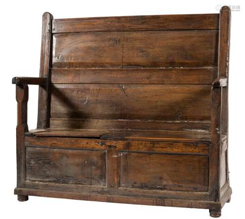 An early 18th century oak box settle: with a fielded twin panel back and twin panelled hinged seat