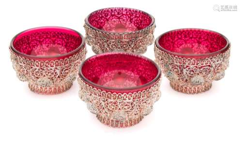 A set of four silver filigree salts: of circular outline with open trellis work of scrolls and