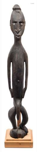 A Papua New Guinea (Sepik river area) carved ebony tribal figure: stained black with inset shell