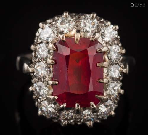 A ruby and diamond oblong cluster ring: with central oblong ruby 11.2mm long x 8.