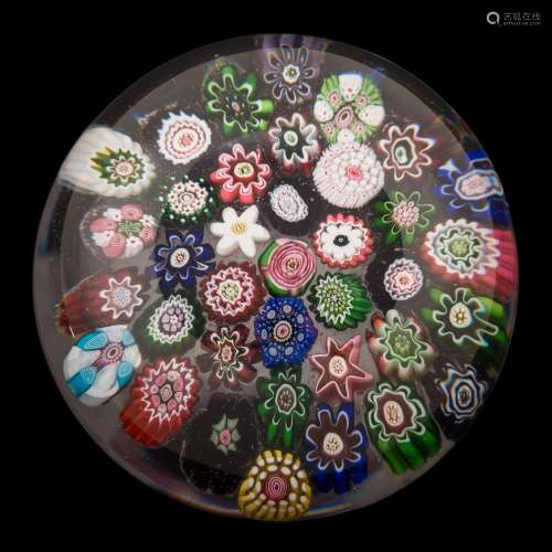 A Clichy close packed millefiori paperweight: set with a variety of coloured canes around a central