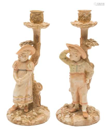 A pair of Royal Worcester 'Kate Greenaway' figural candlesticks: modelled by James Hadley,