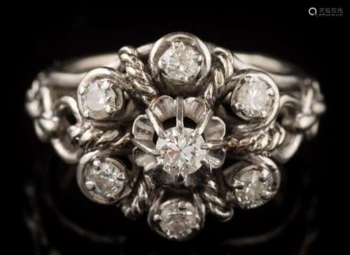 A French platinum and diamond seven-stone cluster ring: of pierced,