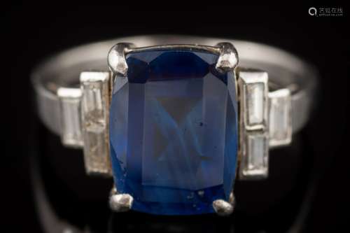 A sapphire and diamond ring: the rectangular sapphire in four-claw setting approximately 10.