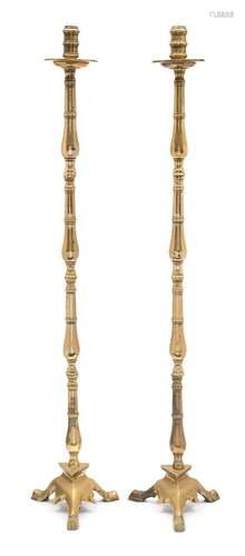 A pair of 19th century brass floor standing candlesticks: with ring turned nozzles,