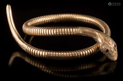 A 9ct gold 'snake' bangle: with hall marked head and tail and pink gem-set eyes.