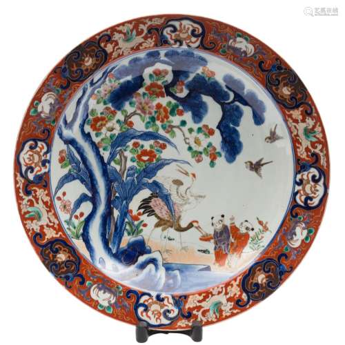 An Arita porcelain charger: decorated in under glaze blue and polychrome enamels with two boys