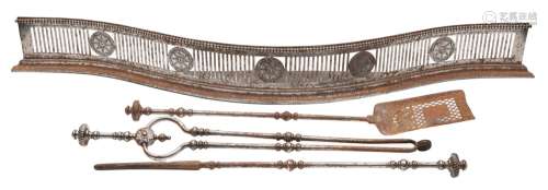 A George III pierced steel serpentine-fronted fender and a set of fire irons: the fender with