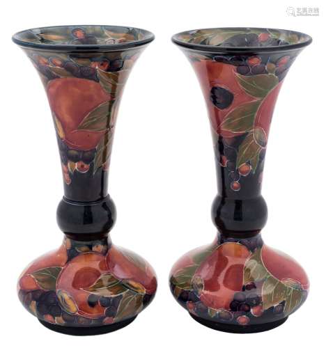 A pair of Moorcroft pottery vases: each of squat form with flaring garlic shaped neck tube lined in