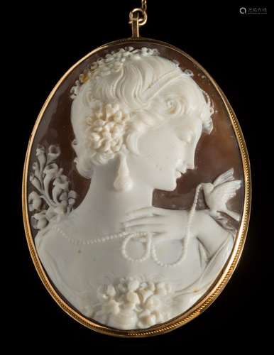 A carved oval shell cameo portrait pendant/brooch: depicting a young woman with pearl necklace and