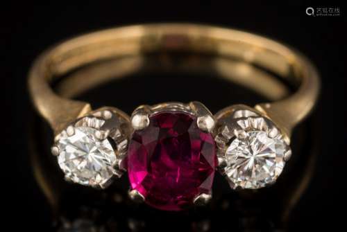 An 18ct gold ruby and diamond three-stone ring: with central oval ruby 6.9mm x 5.