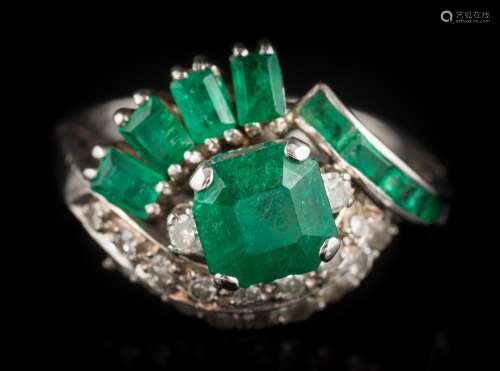 An emerald and diamond cluster ring: the central,