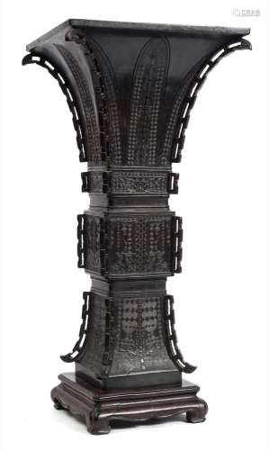 A large Chinese bronze vase, Gu: of square section, the corners with pierced vertical flanges,